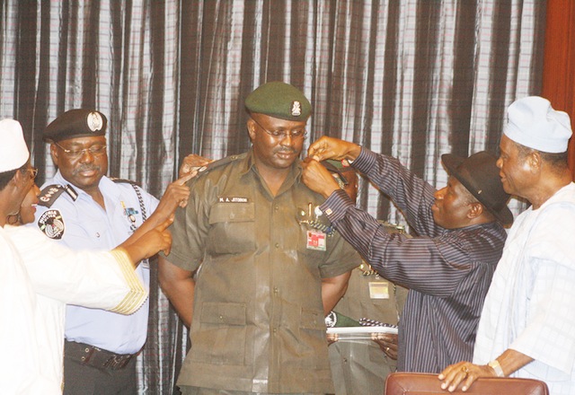 Moses Jitoboh being decorated by President Jonathan, assisted by the IGP Ringim and minister of Police Affairs Adamu Maina Waziri.