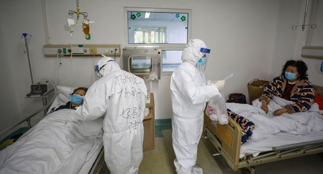 WUHAN, CHINA - FEBRUARY 13 2020: Two medical personnel work in the patients' ward in Jinyintan Hospital, designated for critical COVID-19 patients, in Wuhan in central China's Hubei province Thursday, Feb. 13, 2020. The city reported 13,436 new cases of COVID-19 Feb. 12, a big jump after the city combed communities for patients and expanded the capacity to take them in.- PHOTOGRAPH BY Feature China / Barcroft Media (Photo credit should read Feature China/Barcroft Media via Getty Images)