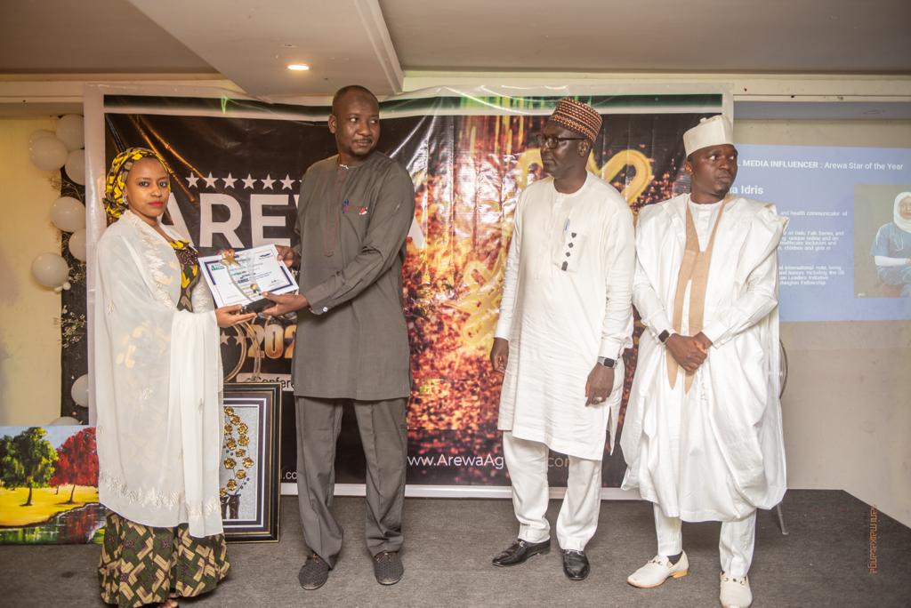 Dr Ibrahim Nura of Faculty of Communication, BUK presents award to a recipient of Arewa Stars award.