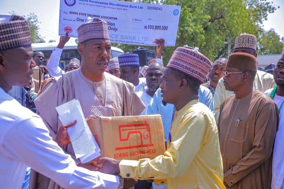 Gov. Zulum hands over a sewing machine to one of the beneficiaries