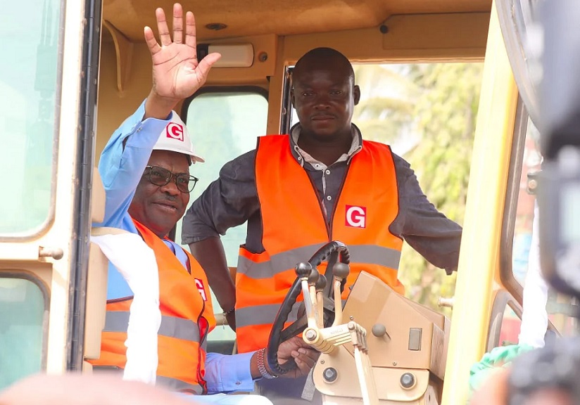 Wike in a tractor waving hands